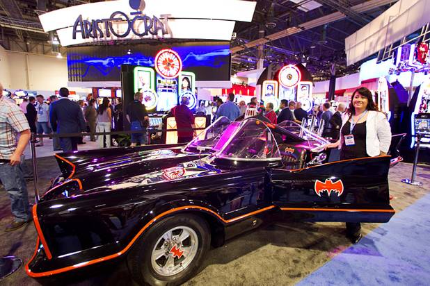 Monica Alcaron of Argentina poses by a replica of the Batmobile, used in the Batman television series (1966-1968), during the G2E convention at the Sands Expo Center Tuesday, Sept. 24, 2013.  The car was there to promote the Batman video slot machines by Aristocrat.
