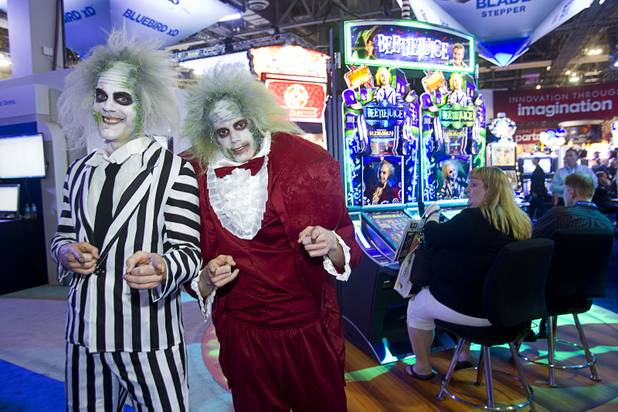 Matt Metzger, left, and James Gildea pose by "Beetlejuice" video slot machines by WMS Gaming during the G2E convention at the Sands Expo Center Tuesday, Sept. 24, 2013.  The slots are themed after the 1988 movie directed byTim Burton.