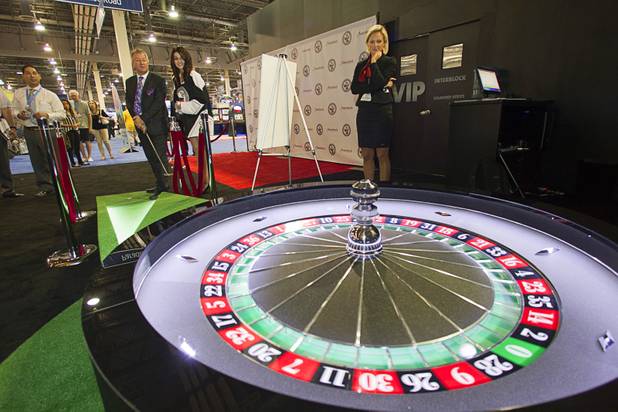 Glyn Thomas, editor of Casino Life magazine, putts a golf ball into a roulette wheel during the G2E convention at Sands Expo Center on Tuesday, Sept. 24, 2013. The game was a booth promotion by Interblock, a developer of multiplayer gaming machines.