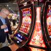 Jose Figueroa of Puerto Rico looks over slot machines in Bally Technologies' Pro Wave cabinets during the G2E convention at the Sands Expo Center Tuesday, Sept. 24, 2013.