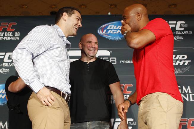 Chris Weidman and Anderson Silva laugh as they face off during a news conference to promote their December fight at UFC 168 Tuesday, Sept. 24, 2013. Silva was covering his mouth in reference to the kiss he gave Weidman during the weigh in for their previous fight.