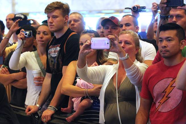 Fans watch a news conference to promote UFC 168 Tuesday, Sept. 24, 2013.
