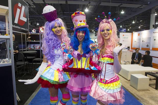 Sami Goldsmith, left, Porsche Youssef, center, and Jackie Unterreiner promote the Sweet 3 video slot machine by IGT during the G2E convention at the Sands Expo Center Wednesday, Sept. 25, 2013.  