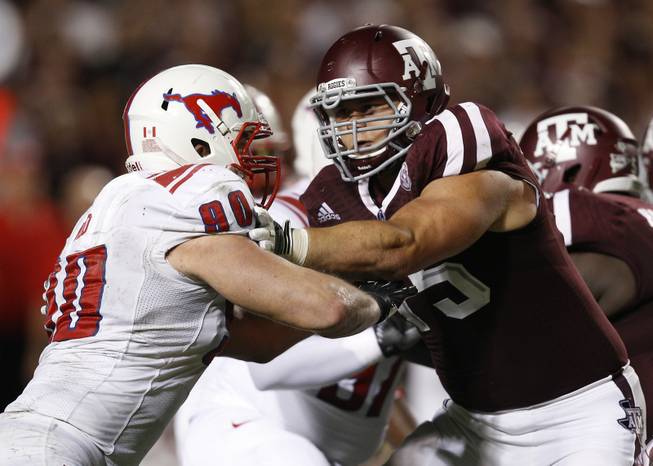 SMU defensive end Zach Wood (90) and Texas A&M offensive linesman Jake Matthews (75) lock up on the line in the fourth quarter during an NCAA college football game Saturday, Sept. 21, 2013, in College Station, Texas. Texas A&M won 42-13. 