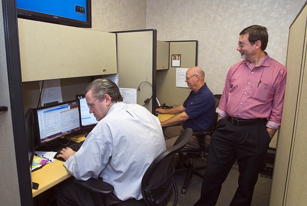 Support specialists Jeff Reynolds, left, and Stan Powell assist clients at the NetEffect service desk Monday, Sept. 30, 2013. Brad Swan, director of support, stands at right. The Las Vegas company provides remote managed IT services, cloud computing, an information technology consulting service, and offsite data backup and recovery services.