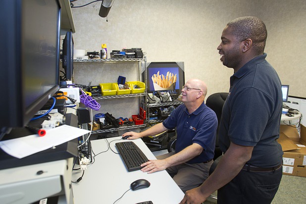 Support specialist Stan Powell, left, and Scott Hill, an on-site gaming support technician, work on a client's computer at the NetEffect service bench Monday, Sept. 30, 2013. The Las Vegas company provides remote managed IT services, cloud computing, an information technology consulting service, and offsite data backup and recovery services.