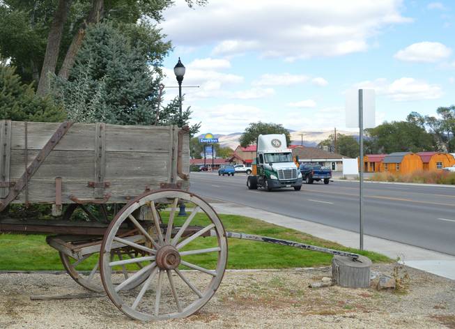 A tractor trailer rig goes by an old wagon at Sherman Station, which dates to the 1880s, in Elko on Sept. 27, 2013.