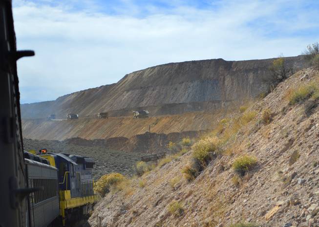 A Nevada Northern Railway train goes around a bend by a copper mine outside of Ely on Sept. 30, 2013. The rail line was put in originally to handle loads of copper, but it no longer does.
