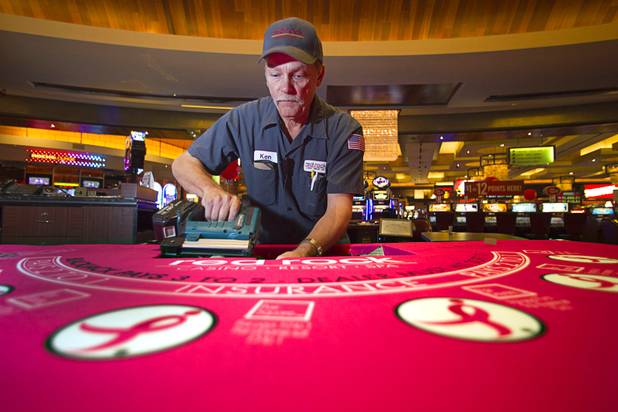 Ken Knight installs pink felt on a blackjack table at Red Rock Resort Tuesday, Oct. 1, 2013. Station Casinos is hosting its fourth annual "Project Pink" initiative for National Breast Cancer Awareness Month. Blackjack table felts were designed and donated by GPI USA. Throughout October, the majority of station properties will donate a portion of its proceeds from Project Pink retail sales and Pink gaming winnings to the Southern Nevada affiliate of Susan G. Komen, an organization supporting breast cancer research.