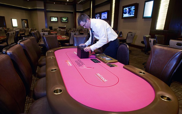 Dennis Stevens installs a shuffle machine in a pink poker table at the Red Rock Resort poker room Tuesday, Oct. 1, 2013. Station Casinos is hosting its fourth annual "Project Pink" initiative for National Breast Cancer Awareness Month. Proceeds from "Poker Goes Pink" will be raised throughout the Oct. 19-20 weekend. Poker table felts were donated by The Layout Company.