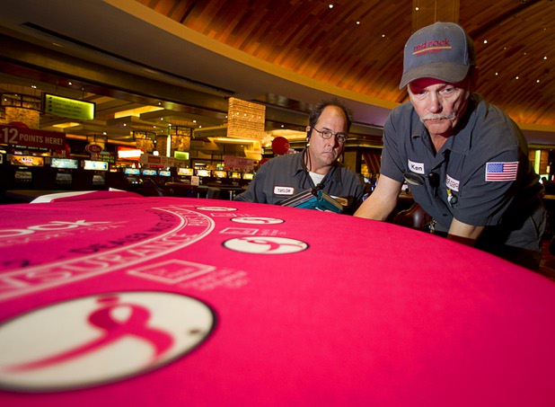 Taylor Gates, left and Ken Knight install pink felt on a blackjack table at Red Rock Resort Tuesday, Oct. 1, 2013. Station Casinos is hosting its fourth annual "Project Pink" initiative for National Breast Cancer Awareness Month. Blackjack table felts were designed and donated by GPI USA. Throughout October, the majority of station properties will donate a portion of its proceeds from Project Pink retail sales and Pink gaming winnings to the Southern Nevada affiliate of Susan G. Komen, an organization supporting breast cancer research.