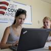 Ashley Hentze, left, of Lakeland, Fla., gets help signing up for the Affordable Care Act from Kristen Nash, a volunteer with Enroll America, a private, nonprofit organization running a grassroots campaign to encourage people to sign up for health care, Tuesday, Oct. 1, 2013  