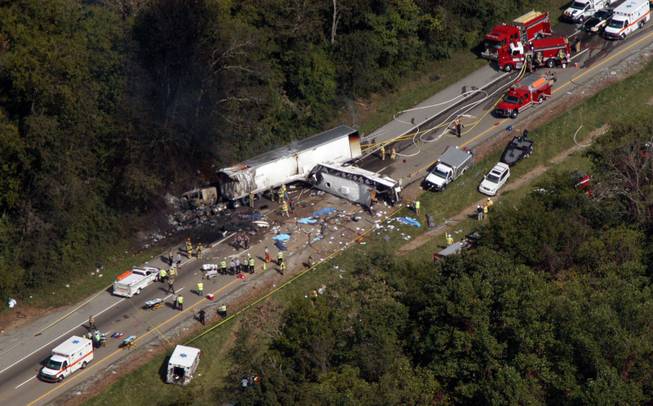 In this aerial photo, emergency workers respond to a crash involving a church bus and a tractor-trailer near Dandridge, Tenn., on Wednesday, Oct. 2, 2013.  Authorities say a tire on the bus blew out and the bus hit the tractor-trailer and a sport utility vehicle, killing eight people.