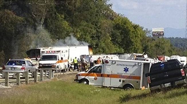 In this image released by WVLT -TV, authorities work at the scene of an interstate accident, near Dandridge, Tenn. on Wednesday, Oct. 2, 2013. A passenger bus has overturned in Jefferson County, completely blocking the eastbound lanes of Interstate 40.