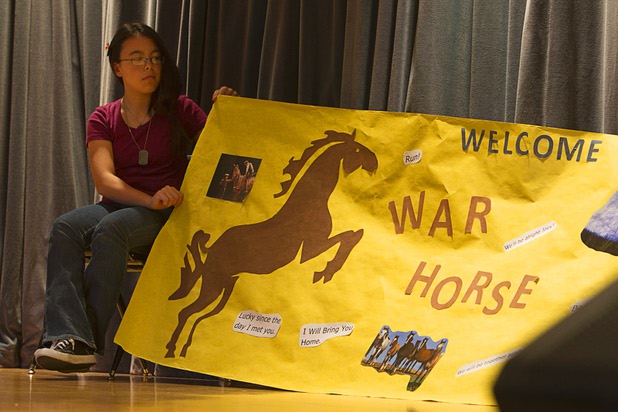 Michelle Squatrito holds a banner welcoming War Horse puppeteers and actor Andy Truschinski at Cram Middle School Thursday, Oct. 3, 2013. One hundred Cram students and teachers will attend a performance of “War Horse,” part of Smith Center's Broadway series, at the center Friday.
