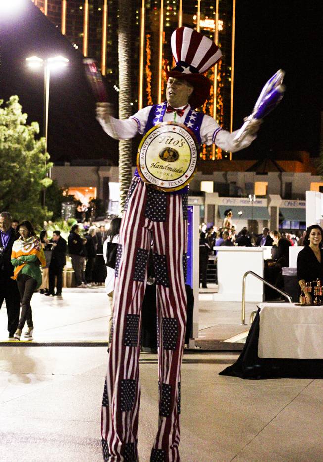 A juggling man on stilts wearing a Tito's Handmade Vodka sign entertains guests during the Epicurean Charitable Foundations M.E.N.U.S. (Mentoring & Educating Nevadas Upcoming Students) fundraising event at the Luxor Oasis Pool on Friday, Oct. 4, 2013.