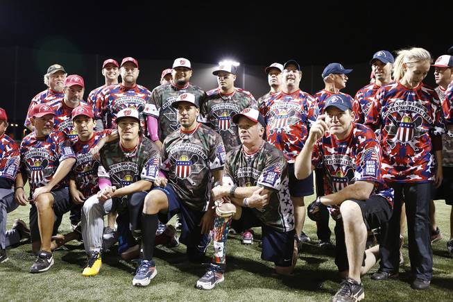 Members of the Wounded Warrior Amputee Softball Team pose for a photo with players participating in the LVSSA/SSUSA World Masters Championships softball tournament after an exhibition game at the Big League Dreams Park in Las Vegas on Friday, October 4, 2013.