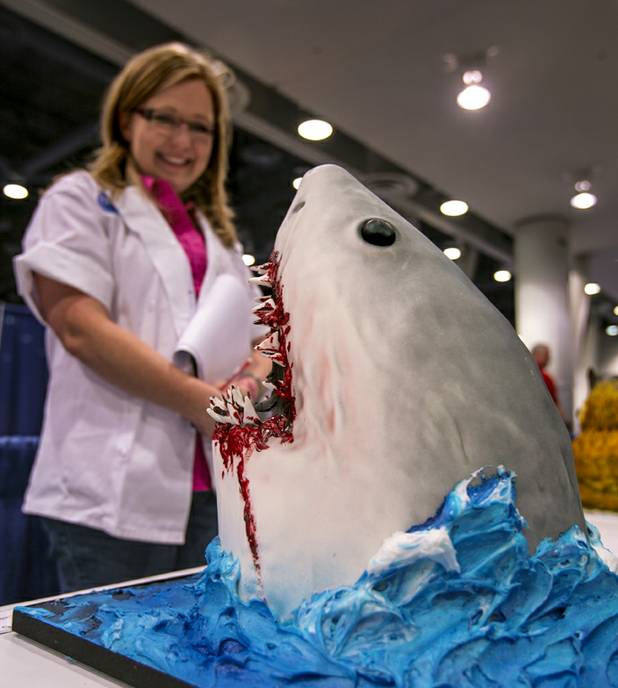 Cake judge Bronwen Weber is pleased by a shark cake on display as part of the Pillsbury Baker's Plus Grand Champion Decorating Competition during the International Baking Industry Exposition at the Las Vegas Convention Center.  