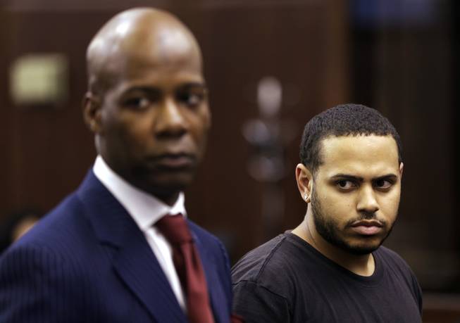Christopher Cruz, right, appears in criminal court with his lawyer H. Benjamin Perez in New York, Wednesday, Oct. 2, 2013. Cruz was charged Wednesday with reckless driving after prosecutors said he touched off a tense encounter with the driver of an SUV and a throng of other bikers.