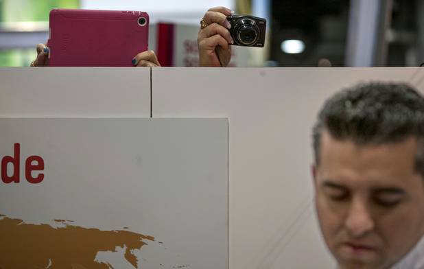 Attendees at the International Baking Industry Exposition grab pictures over the wall of Buddy Valastro, the famed "Cake Boss" who is gathering himself to meet his fans at the Las Vegas Convention Center.
