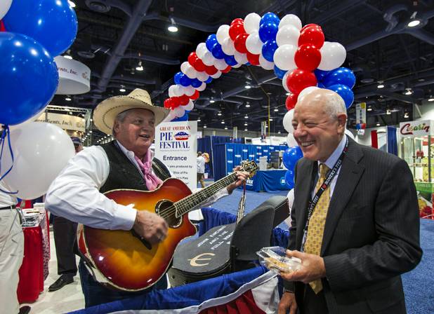 (From left) Guitar player John Encino of Las Vegas sings "Boy Named Sue" to the enjoyment of Michael Bonert of Santa Ana, Calif. during the International Baking Industry Exposition in the Las Vegas Convention Center.  Bonert is the CEO/president of Bonerts Slice of Pie which has a large display and plenty of pie for attendees to sample.  