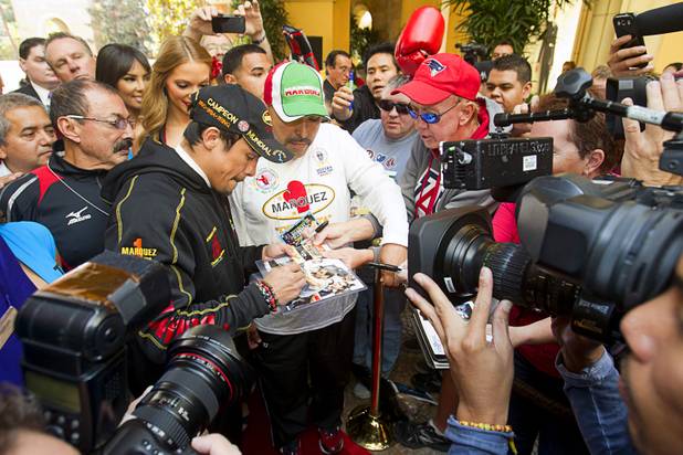 Mexican boxer Juan Manuel Marquez is surrounded by reporters and fans as he arrives at the Wynn Las Vegas Resort Tuesday, Oct. 8, 2013. Marquez will challenge undefeated WBO welterweight champion Timothy Bradley Jr. at the Thomas & Mack Center Saturday.