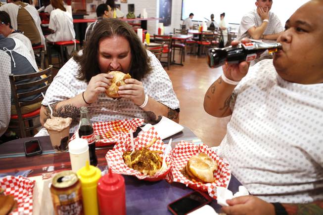 Willie Pape, left, and Joe Monroy, both of Orange County, Calif. enjoy their meals at the Heart Attack Grill in downtown Las Vegas on Tuesday, October 8, 2013.