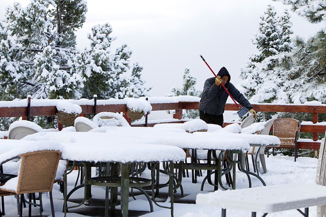 Manuel Franco cleans snow from chairs and tables on the patio of the Mt. Charleston Lodge on Mount Charleston Thursday, Oct. 10, 2013.