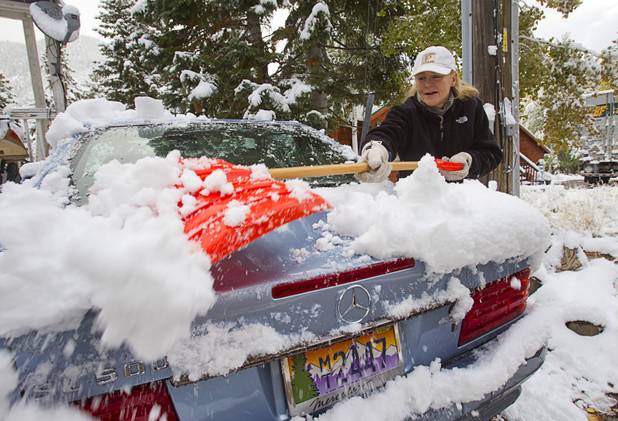 Marci Simmons clears snow from her car in the Cathedral subdivision on Mount Charleston Thursday, Oct. 10, 2013.