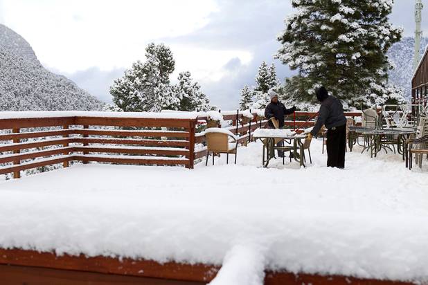 Workers clear snow from the patio of the Mt. Charleston Lodge Thursday, Oct. 10, 2013.
