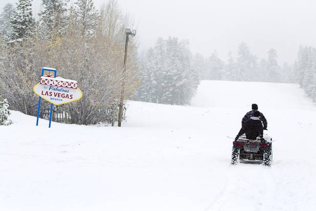 Snowboarder Jake Buell gets a ride up a slope on an ATV from Logan Aug at the Las Vegas Ski & Snowboard Resort in Lee Canyon Thursday, Oct. 10, 2013.