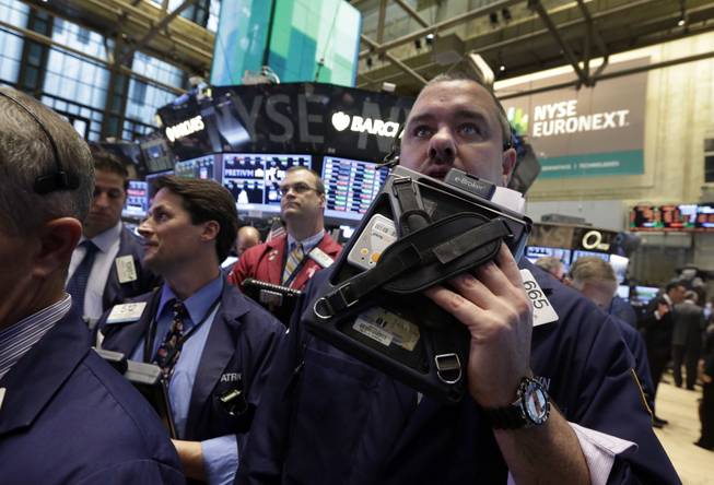 Trader Kevin Lodewick, right, works on the floor of the New York Stock Exchange Wednesday, Oct. 9, 2013.