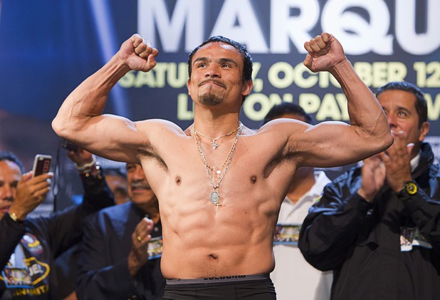 Juan Manuel Marquez of Mexico flexes on the scale during an official weigh-in at the Wynn Las Vegas Friday, Oct. 11, 2013. Marquez will challenge undefeated WBO welterweight champion Timothy Bradley Jr.  for the title at the Thomas & Mack Center on Saturday.