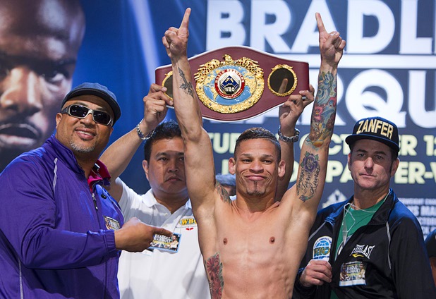 Featherweight boxer Orlando Cruz of Puerto Rico poses during an official weigh-in at the Wynn Las Vegas Friday, Oct. 11, 2013. With Cruz are trainer Juan De Leon, left, and Sean Gibbons of Zanfer Promotions. Cruz, boxing's first openly gay fighter, and Orlando Salido of Mexico will fight for a vacant WBO featherweight championship at the Thomas & Mack Center on Saturday.
