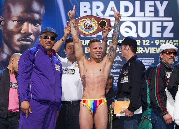 Featherweight boxer Orlando Cruz (C) of Puerto Rico poses during an official weigh-in at the Wynn Las Vegas Friday, Oct. 11, 2013. Trainer Juan De Leon is at left. Cruz, boxing's first openly gay fighter, and Orlando Salido of Mexico will fight for a vacant WBO featherweight championship at the Thomas & Mack Center on Saturday.