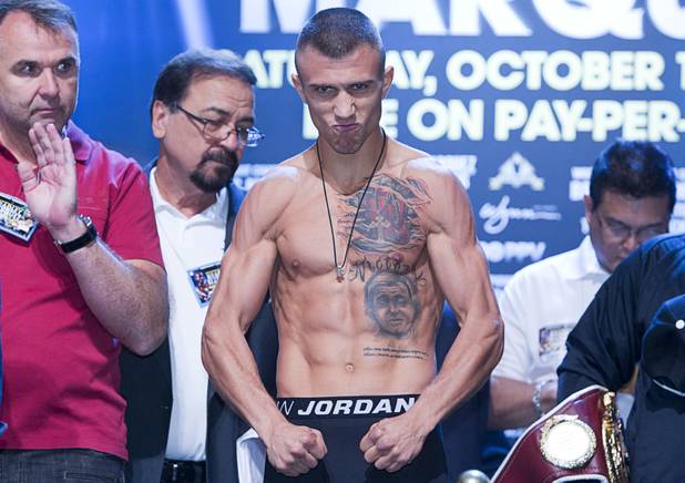Featherweight boxer Vasyl Lomachenko (C) of Ukraine poses on the scale during an official weigh-in at the Wynn Las Vegas Friday,, Oct. 11, 2013. Two-time Olympic gold medalist Lomachenko will make his pro debut against Jose Ramirez of Mexico at the Thomas & Mack Center on Saturday.