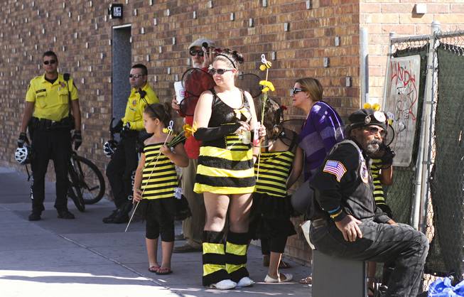 Protesters dressed in bee costumes and bike cops gather behind Backstage Bar & Billiards on Fremont Street for the "March Against Monsanto" protest opposing genetically modified food in downtown Las Vegas, Saturday, Oct. 12, 2013.