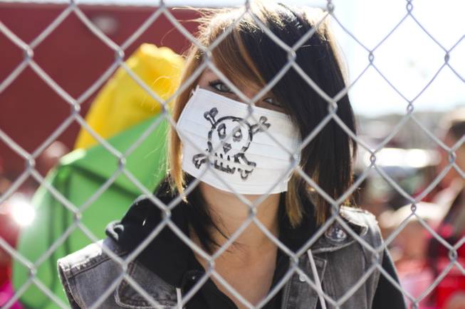 A protester wears a mouth mask with a skull on it during the "March Against Monsanto" protest opposing genetically modified food in downtown Las Vegas, Saturday, Oct. 12, 2013.