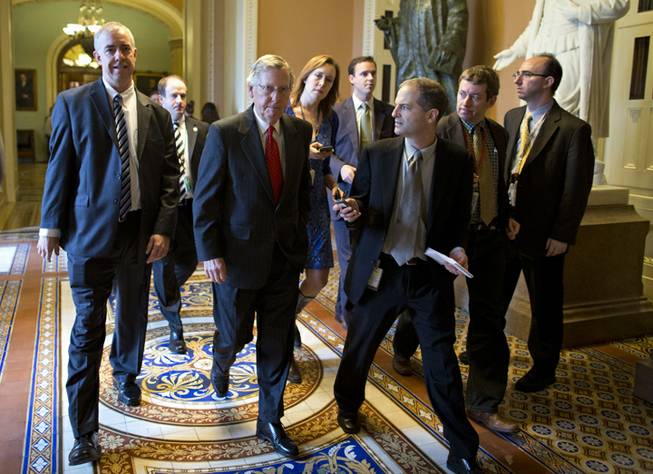 Senate Minority Leader Mitch McConnell of Ky., is pursued by reporters after returning to Capitol Hill in Washington, Friday, Oct. 11, 2013, following a meeting between Republican senators and President Obama at the White House. Republicans from the House of Representatives are offering to pass legislation to avert a potentially catastrophic default and end the 11-day partial government shutdown as part of a framework that would include cuts in benefit programs, officials said Friday. it standoff.