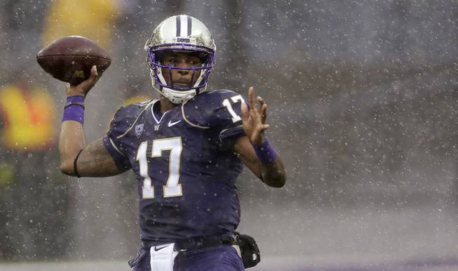Washington quarterback Keith Price passes in the rain during the first half of an NCAA college football game against Arizona, Saturday, Sept. 28, 2013, in Seattle.