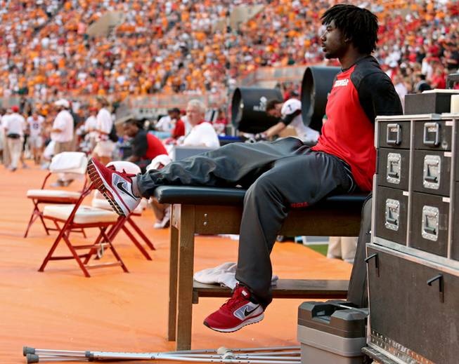 Georgia's Keith Marshall, right, sits on a training table during an NCAA college football game against Tennessee in Knoxville, Tenn., Oct. 5, 2013. 