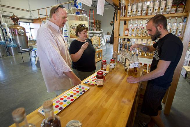 Distillery worker Jason Nichol shows a variety of spirits to Matt and Sheryl Cummings during tastings at the Las Vegas Distillery in Henderson Saturday, Oct. 12, 2013. The distillery unveiled their newest spirit called Grandma's Apple Pie Moonshine. The distillery will feature additional tastings on Oct. 19 and 26.