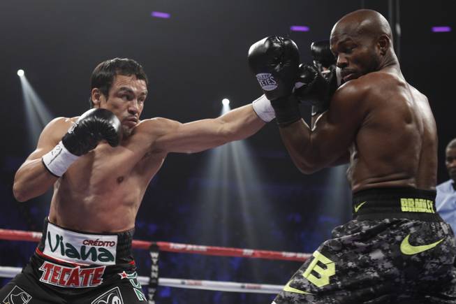 Juan Manuel Marquez, left, of Mexico, punches at WBO welterweight champion Timothy Bradley Jr. of the U.S during their title fight at the Thomas & Mack Center in Las Vegas, Nevada, Oct. 12, 2013.