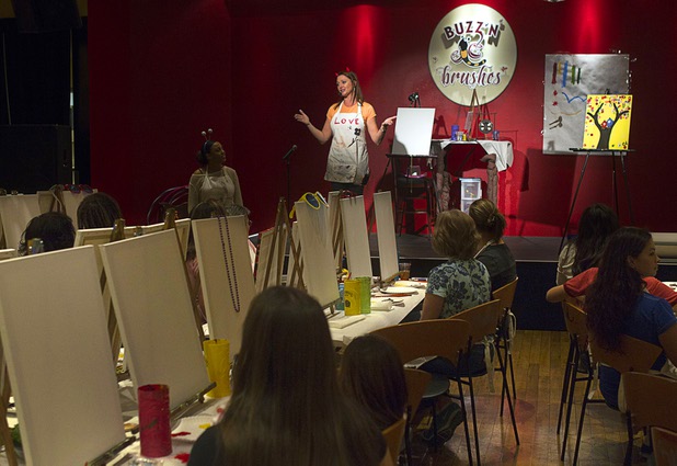 "BeeExtraordinaire" Caroline App leads a class at the Buzz'N Brushes art studio in the Orleans Sunday, Oct. 13, 2013.  The studio combines art and entertainment for beginners and shares space with a bar and pizza kitchen.