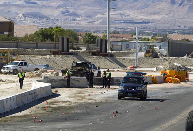Nevada Highway Patrol troopers and investigators look over a jersey wall after a fatal crash involving a cement truck on the northern 215 beltway near Jones Boulevard Tuesday, Oct. 15, 2013. The cement truck apparently stuck the wall, then continued along the wall eastbound before turning over and catching fire, said NHP officer Jeremie Elliott. The accident has closed the beltway in both directions between Jones Boulevard and Sky Pointe Drive.