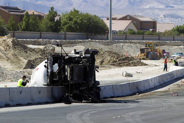 A Nevada Highway Patrol trooper photographs a cement truck after a fatal crash on the northern 215 beltway near Jones Boulevard Tuesday, Oct. 15, 2013. The cement truck apparently stuck the wall, then continued along the wall eastbound before turning over and catching fire, said NHP officer Jeremie Elliott. The accident has closed the beltway in both directions between Jones Boulevard and Sky Pointe Drive.