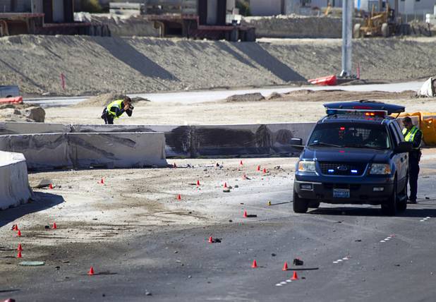 A Nevada Highway Patrol trooper photographs a jersey wall after a fatal crash involving a cement truck on the northern 215 beltway near Jones Boulevard Tuesday, Oct. 15, 2013. The cement truck apparently stuck the wall, then continued along the wall eastbound before turning over and catching fire, said NHP officer Jeremie Elliott. The accident has closed the beltway in both directions between Jones Boulevard and Sky Pointe Drive.