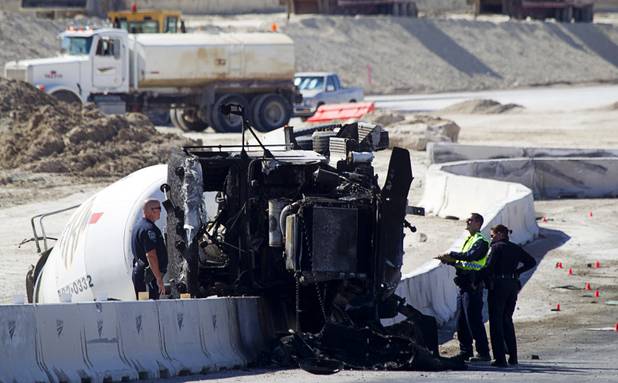 Nevada Highway Patrol troopers look over a cement truck after a fatal accident on the northern 215 beltway near Jones Boulevard Tuesday, Oct. 15, 2013. The cement truck apparently stuck the jersey wall, then continued along the wall eastbound before turning over and catching fire, said NHP officer Jeremie Elliott. The accident has closed the beltway in both directions between Jones Boulevard and Sky Pointe Drive.