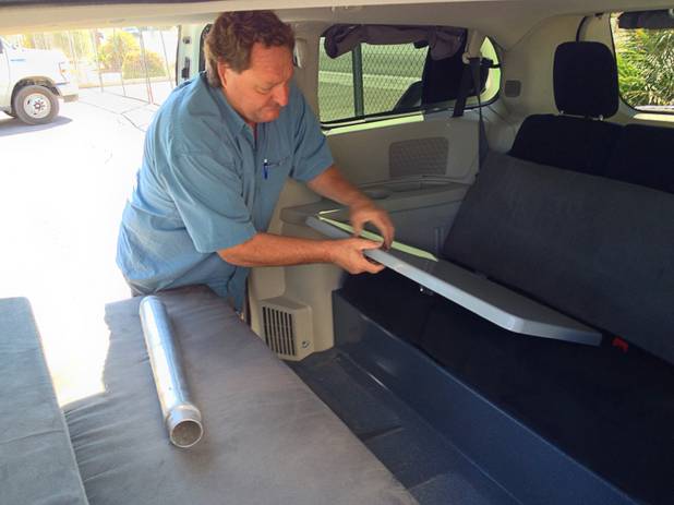 Kurt Luthy of Apollo converts the kitchen table into the double bed, removing the pole holding the table and sliding the table to support the mattress. .