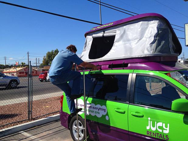 Kurt Luthy climbs down from the penthouse to stow the bed and tent away for travel.